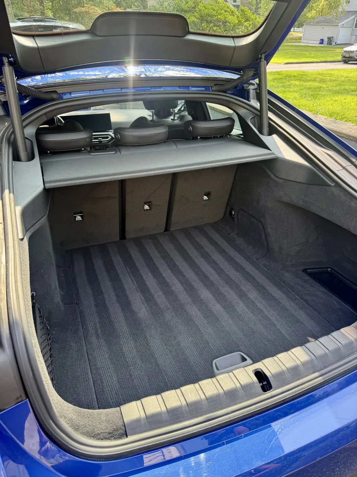 Clean, dry gray trunk carpet with vacuum lines in a blue BMW hatchback