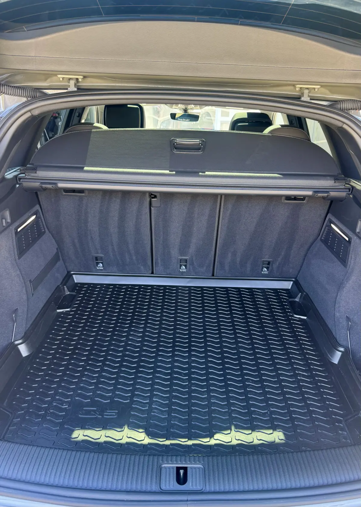 Audi Q5 cargo area with a rubber liner and clean gray seatback carpet