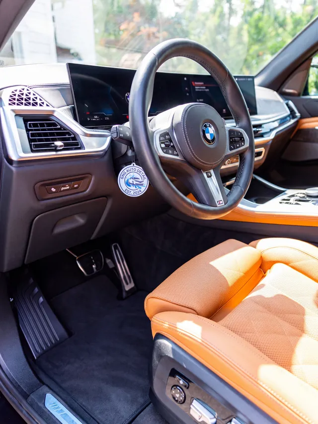 BMW X5 dashboard, steering wheel, and cognac leather seat after an interior detail