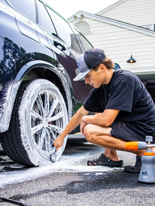 Christian foam cannon cleaning a BMW wheel and tire during a mobile exterior detail