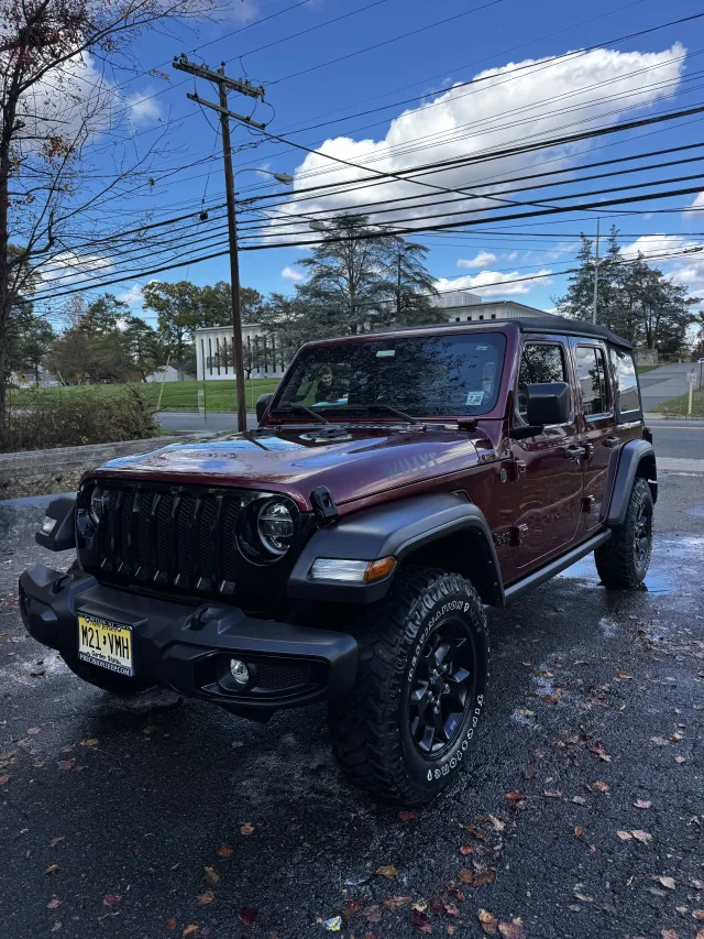 Maroon Jeep Wrangler with clean paint and dressed tires after an exterior detail